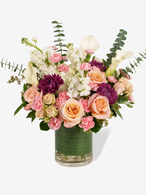 secret garden bouquet with roses, stock, calla lilies, spray roses, and miniature carnations.
