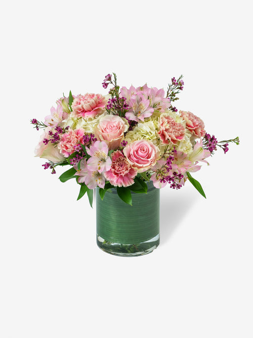everyday love bouquet with pink roses, alstroemerias, and carnations in a glass vase.