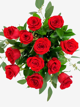 One dozen premium red roses in a stylish vase, a timeless gift for anniversaries.